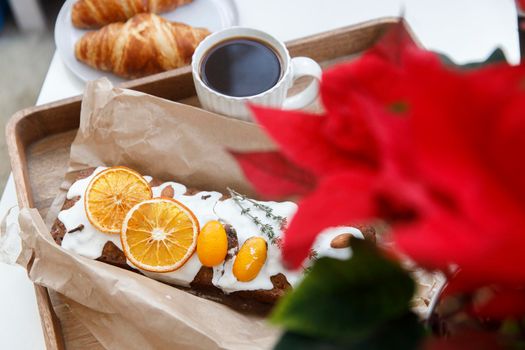 Traditional christmas cupcake garnished with dry orange wedges, clove spice and rosemary sprig in craft paper