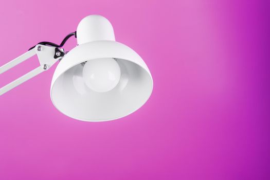 Office table lamp on pink background with space for text and idea concept