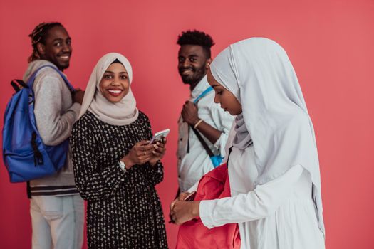 A group of African Muslim students with backpacks posing on a pink background. the concept of school education. High-quality photo