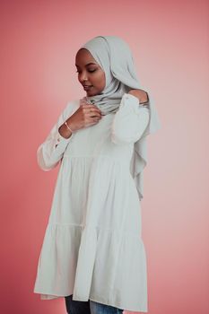 Portrait of young modern muslim afro beauty wearing traditional islamic clothes on plastic pink background. Selective focus. High quality photo