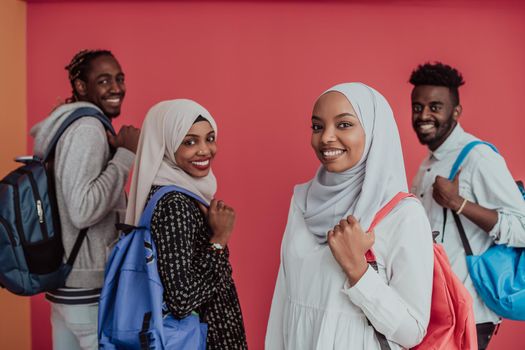 A group of African Muslim students with backpacks posing on a pink background. the concept of school education. High-quality photo