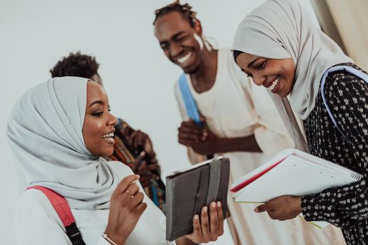 African female student with a group of friends in the background wearing traditional Islamic hijab clothes. Selective focus. High-quality photo