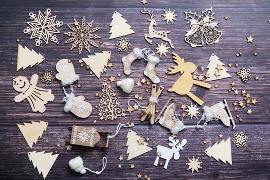 Wooden handmade snowflake toys on dark wooden Christmas background. Crafts cut from eco friendly wood material. Ecological home decor for winter holiday. Copy space. Frame