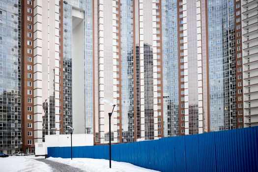 KHIMKI, RUSSIA - February, 2021: View Of the new Khimki . Construction of a new modern district. Moscow region. Blue construction fence and road