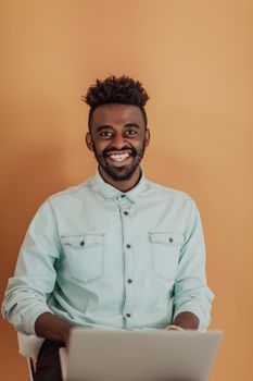 African student using laptop computer to study and make business connections yellow background. High quality photo