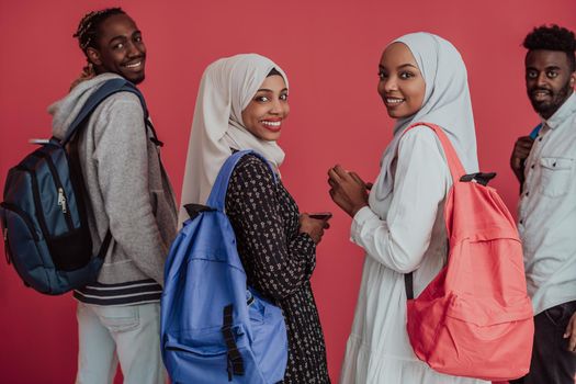 A group of African Muslim students with backpacks posing on a pink background. the concept of school education. High-quality photo