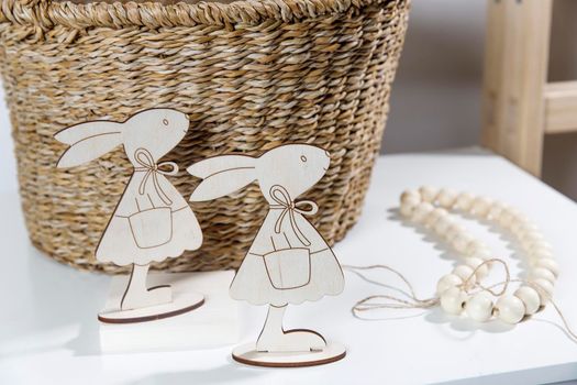 Interior decoration for Easter. A rag rabbit peeks out of a wicker willow basket on the table.