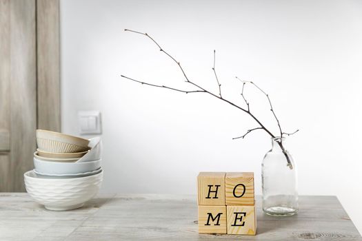 An unblown linden branch in a glass vase and four wooden cubes with space for text. Scandinavian style. Copy text