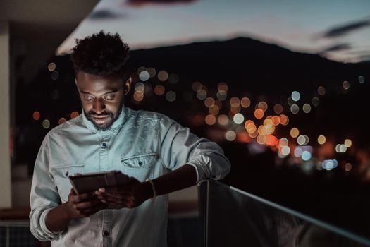 The young man on an urban city street at night texting on a smartphone with bokeh and neon city lights in the background. High-quality photo. High-quality photo