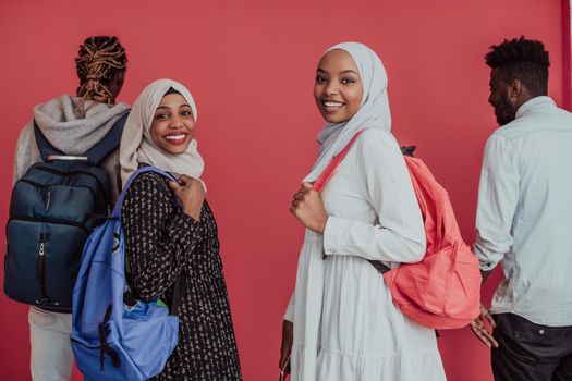 A group of African Muslim students with backpacks posing on a pink background. the concept of school education. High-quality photo