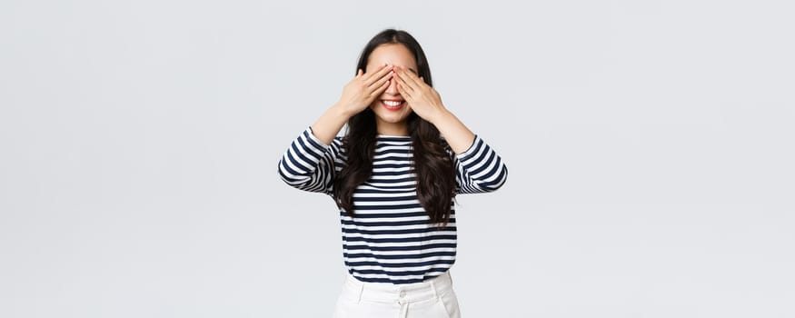 Lifestyle, beauty and fashion, people emotions concept. Dreamy gorgeous asian girl anticipating surprise. Asian woman close eyes and smiling, waiting for signal to receive gift.