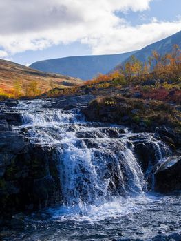 Beautiful mountain waterfall among rocks in polar summer in Khibiny Mountains. Kola Peninsula, Arctic, polar summer. photo