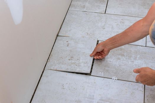 Laying floor ceramic tile with applying tile adhesive the renovating house
