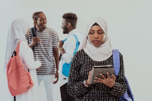 African female student with a group of friends in the background wearing traditional Islamic hijab clothes. Selective focus. High-quality photo