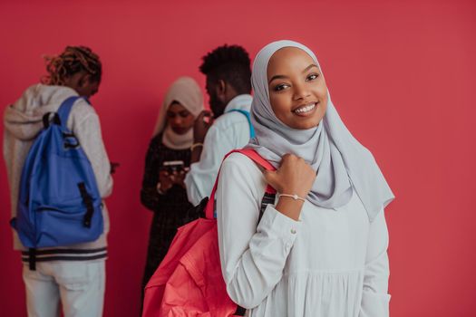 A group of African Muslim students with backpacks posing on a pink background. the concept of school education. High-quality photo