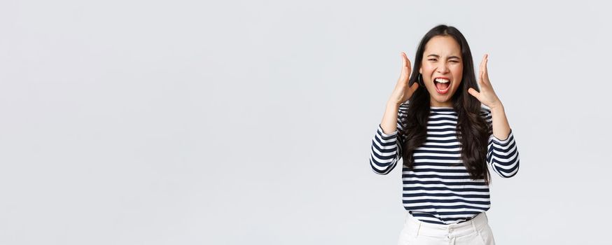 Lifestyle, people emotions and casual concept. Mad distressed asian woman losing temper, cant stand it anymore, freak-out complaining, shouting as having argument, shaking hands aggressive.