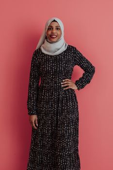 Portrait of young modern muslim afro beauty wearing traditional islamic clothes on plastic pink background. Selective focus. High quality photo