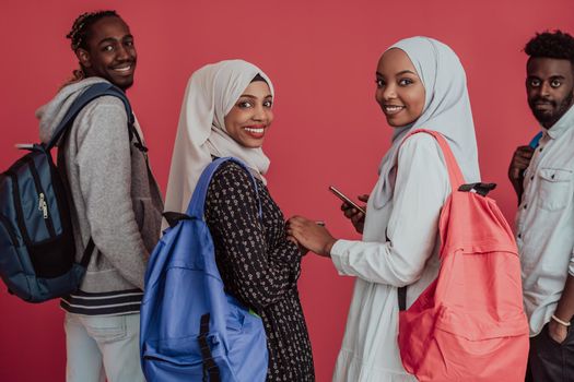 A group of African Muslim students with backpacks posing on a pink background. the concept of school education. High-quality photo