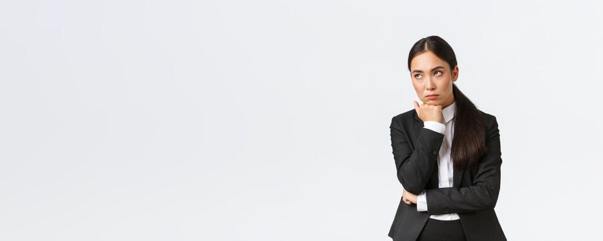 Bored and annoyed female entrepreneur looking unamused away while sitting boring meeting, attend uninteresting office gathering, standing white background dying boredom.