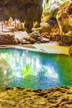 Amazing blue turquoise water and limestone cave sinkhole cenote at Santuario de los guerreros in Puerto Aventuras Quintana Roo Mexico.