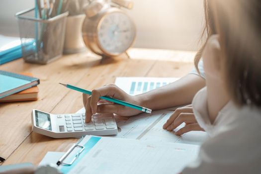 Close up of businessman or accountant working on calculator to calculate business data, accountancy document at meeting room.