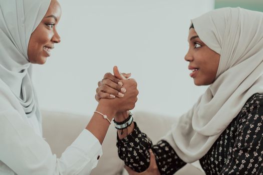 African women arm wrestling conflict concept, disagreement, and confrontation wearing traditional Islamic hijab clothes. Selective focus. High-quality photo