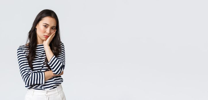 Lifestyle, beauty and fashion, people emotions concept. Annoyed and embarrassed young asian woman stare with dismay and judgement at camera, facepalm, standing white background.