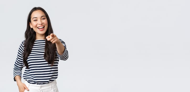 Lifestyle, beauty and fashion, people emotions concept. Happy cheerful asian girl praising you, picking person, found excellent employee for job position, pointing camera and smiling.