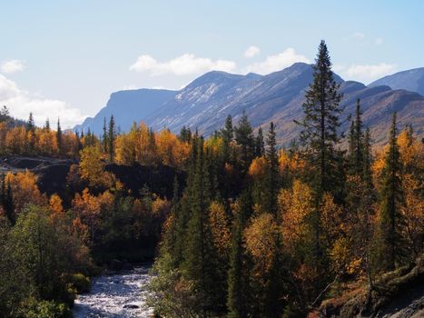 Autumn colorful tundra on the background mountain peaks in cloudy weather. Mountain landscape in Kola Peninsula, Arctic, Khibiny Mountains. photo