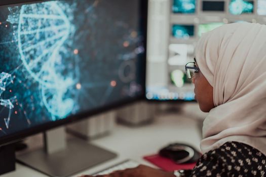 Young Afro-American modern Muslim businesswoman wearing a scarf in a creative bright office workplace with a big screen. High-quality photo