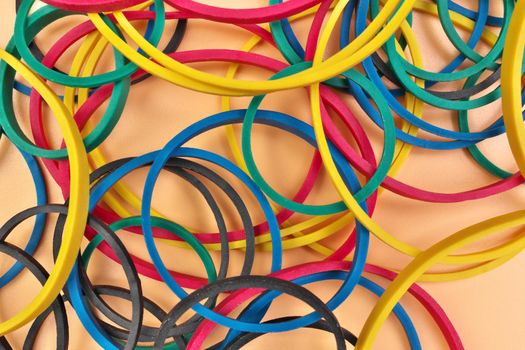 Full Frame Flatlay Image of Multicolored Elastic Rubber Bands on a Cheerful Orange Pastel Background. High quality photo