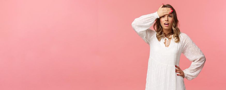 Girl have lots of problems on her mind. Troubled and concerned young blond woman in white dress, hold hand on forehead look desperate and uneasy, dont know what do, being indecisive.