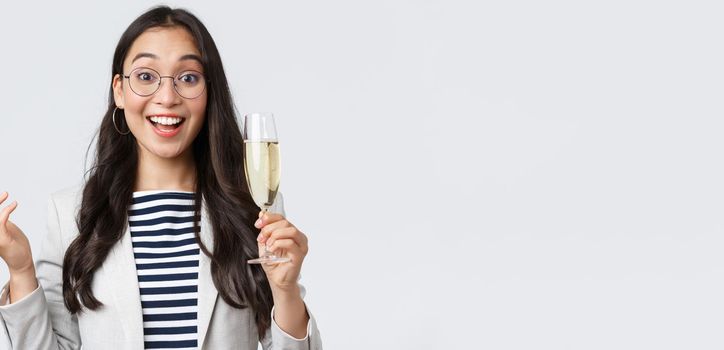 Business, finance and employment, female successful entrepreneurs concept. Enthusiastic happy businesswoman celebrating good deal, have office party with coworkers, make toast with glass champagne.