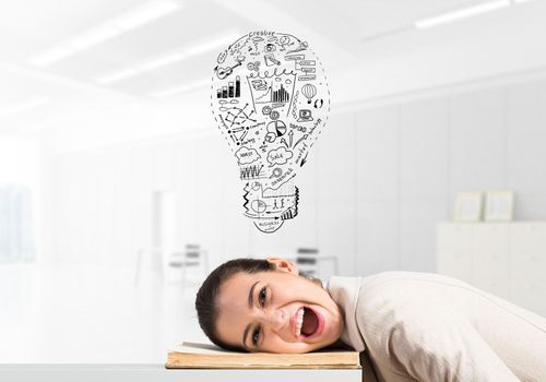 Business woman lying on desk with open mouth. Idea light bulb sketch with business doodles above head. Young female worker in white suit being sleepy head. Paperwork deadline and overwork in office