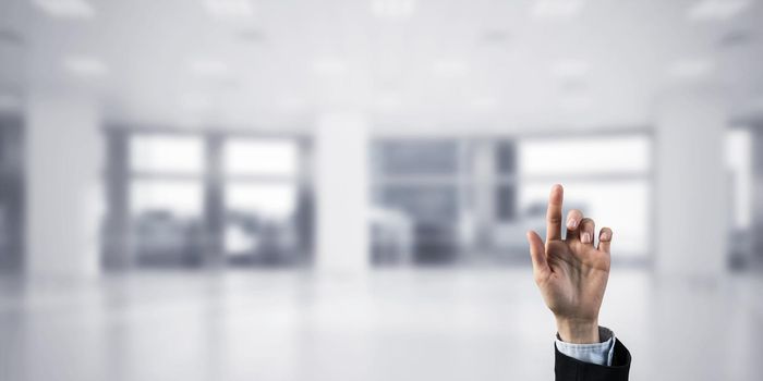 Close of businesswoman hand touching screen with finger and office at background