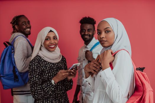 A group of African Muslim students with backpacks posing on a pink background. the concept of school education. High-quality photo