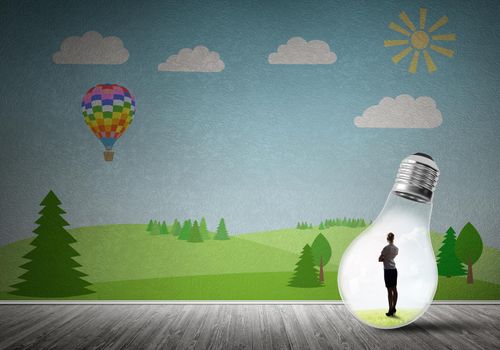 Businesswoman inside light bulb in room against nature drawn concept