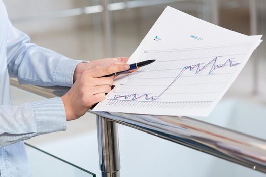 close-up of women's hands, with business papers. charts and numbers on documents