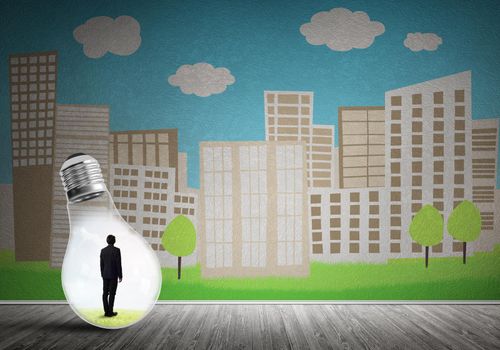 Businessman inside light bulb against city drawn concept