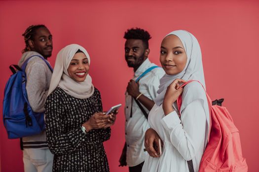 A group of African Muslim students with backpacks posing on a pink background. the concept of school education. High-quality photo