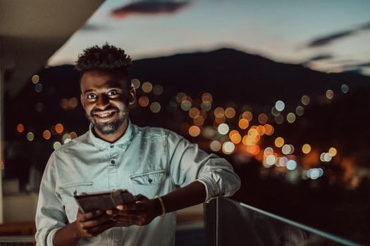 The young man on an urban city street at night texting on a smartphone with bokeh and neon city lights in the background. High-quality photo. High-quality photo