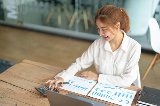 data analysis, marketing, accounting, auditing, portrait of business woman using marketing planning calculator using statistical data sheet, computer to present a marketing plan project at a meeting