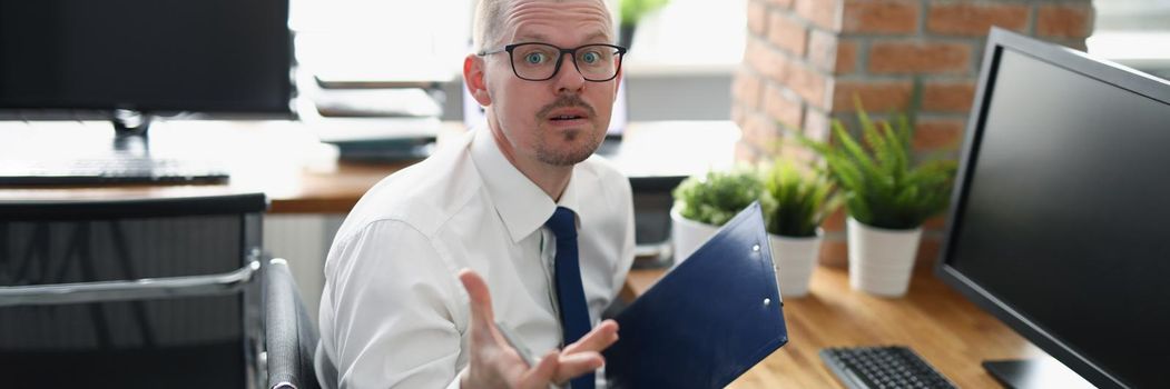 Portrait of employee with mixed emotions, loaded with work, stressed with paperwork. Man in suit on workplace, hard working all day, no break for lunch. Business, job concept