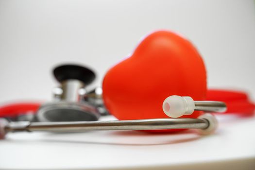 Stethoscope and red heart on white background, heart health, health insurance concept.