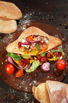 Doner kebab or pita on a wooden tray.