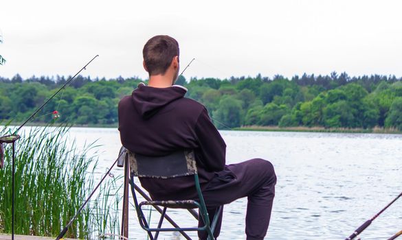 Close-up of a fishing rod wheel, a man is fishing. Nature. selective focus