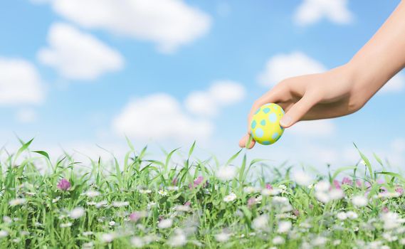 close-up of a hand holding an easter egg in a field full of flowers. 3d rendering