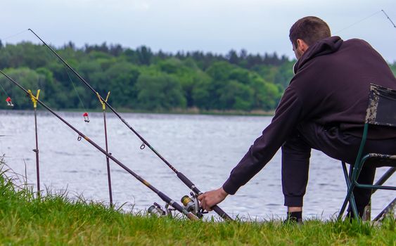 Close-up of a fishing rod wheel, a man is fishing. Nature. selective focus