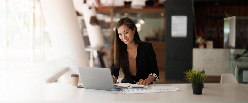 Portrait asian business woman working on laptop computer and calculator for financial. business accounting concept.