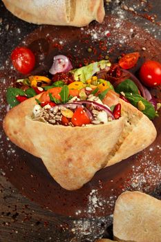 Doner kebab or pita on a wooden tray.